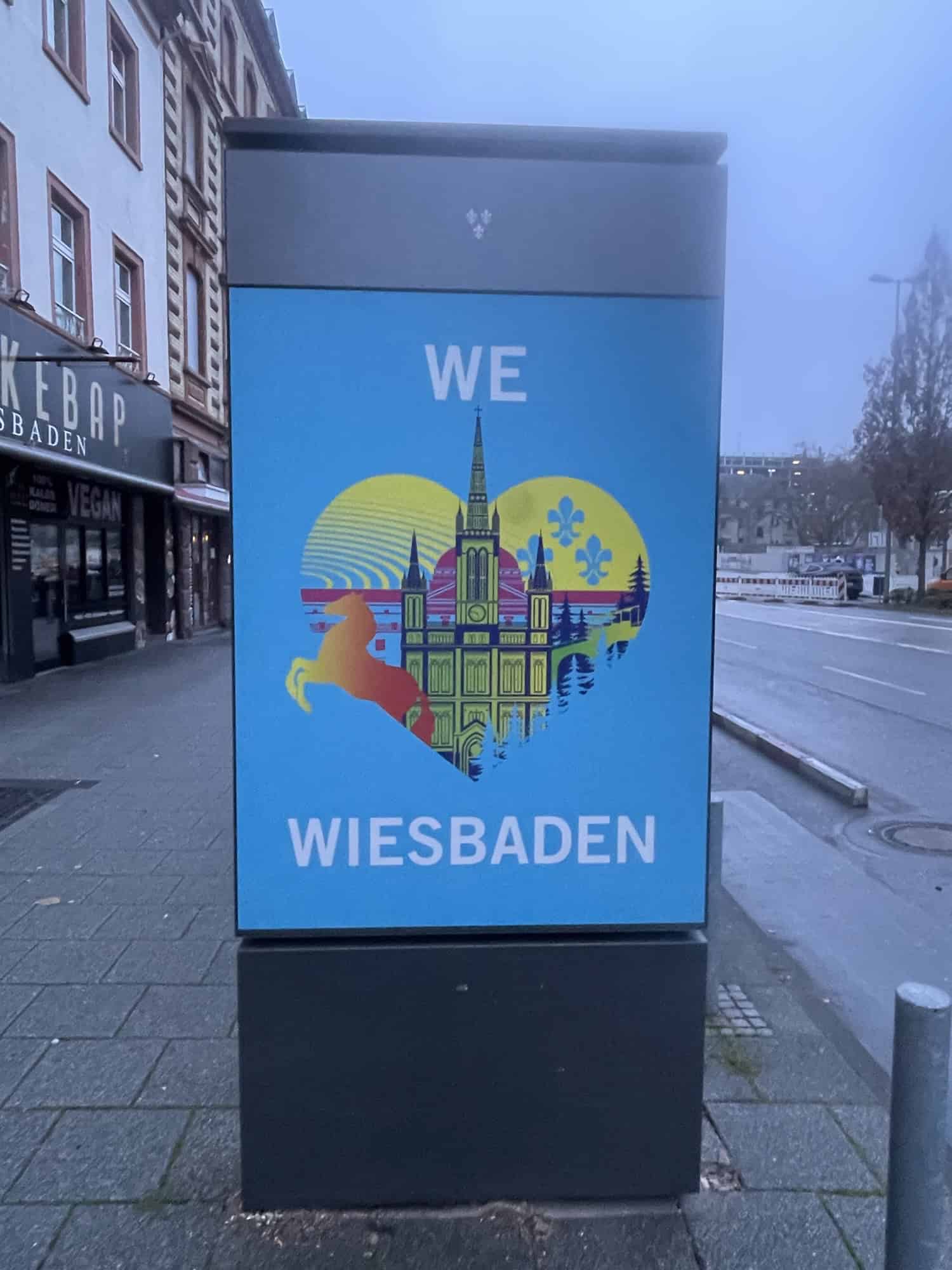 Kleinere Außenwerbung mit 'We love Wiesbaden' im Hellen.