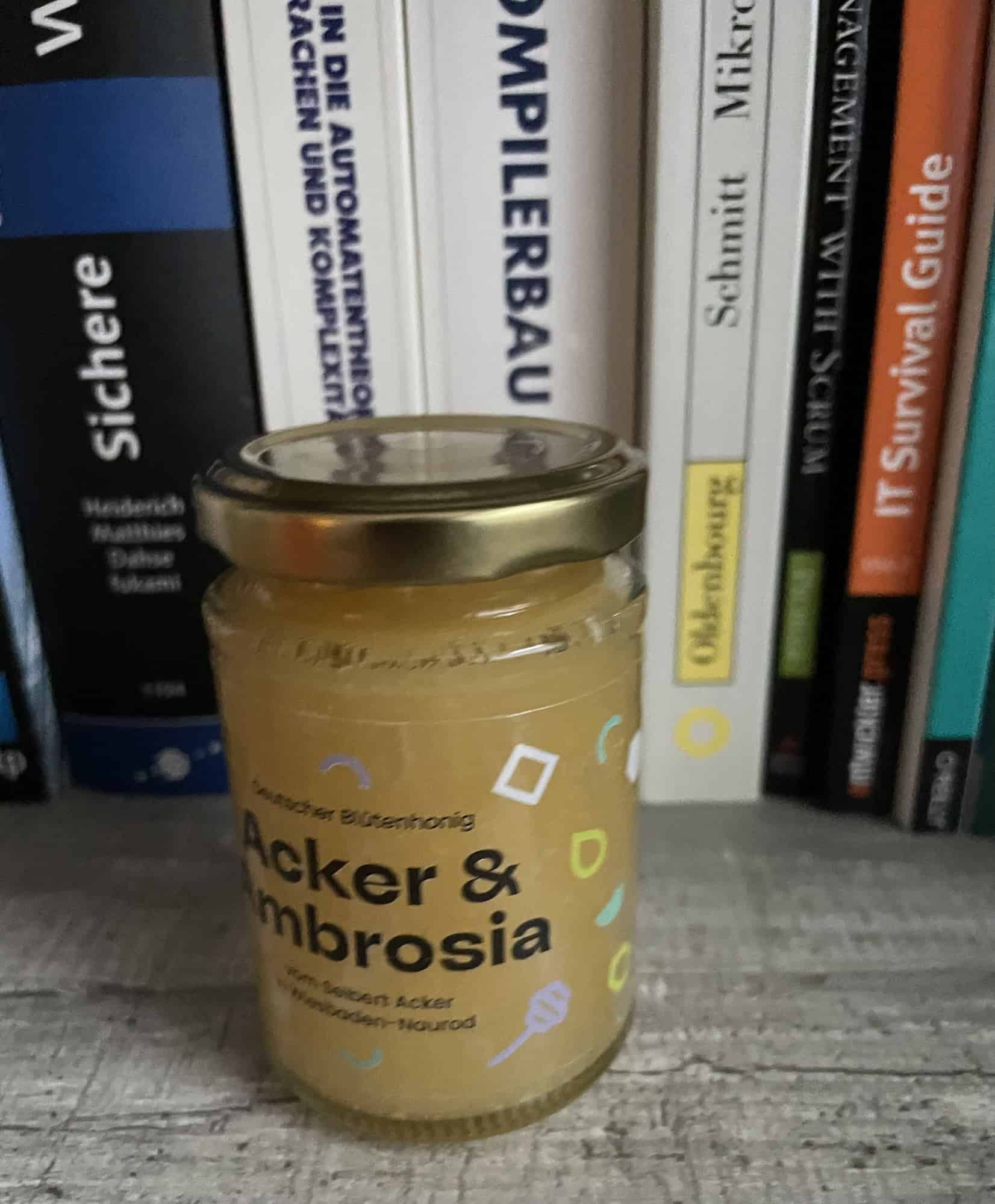 Glas Honig steht vor Regal mit IT-Büchern.