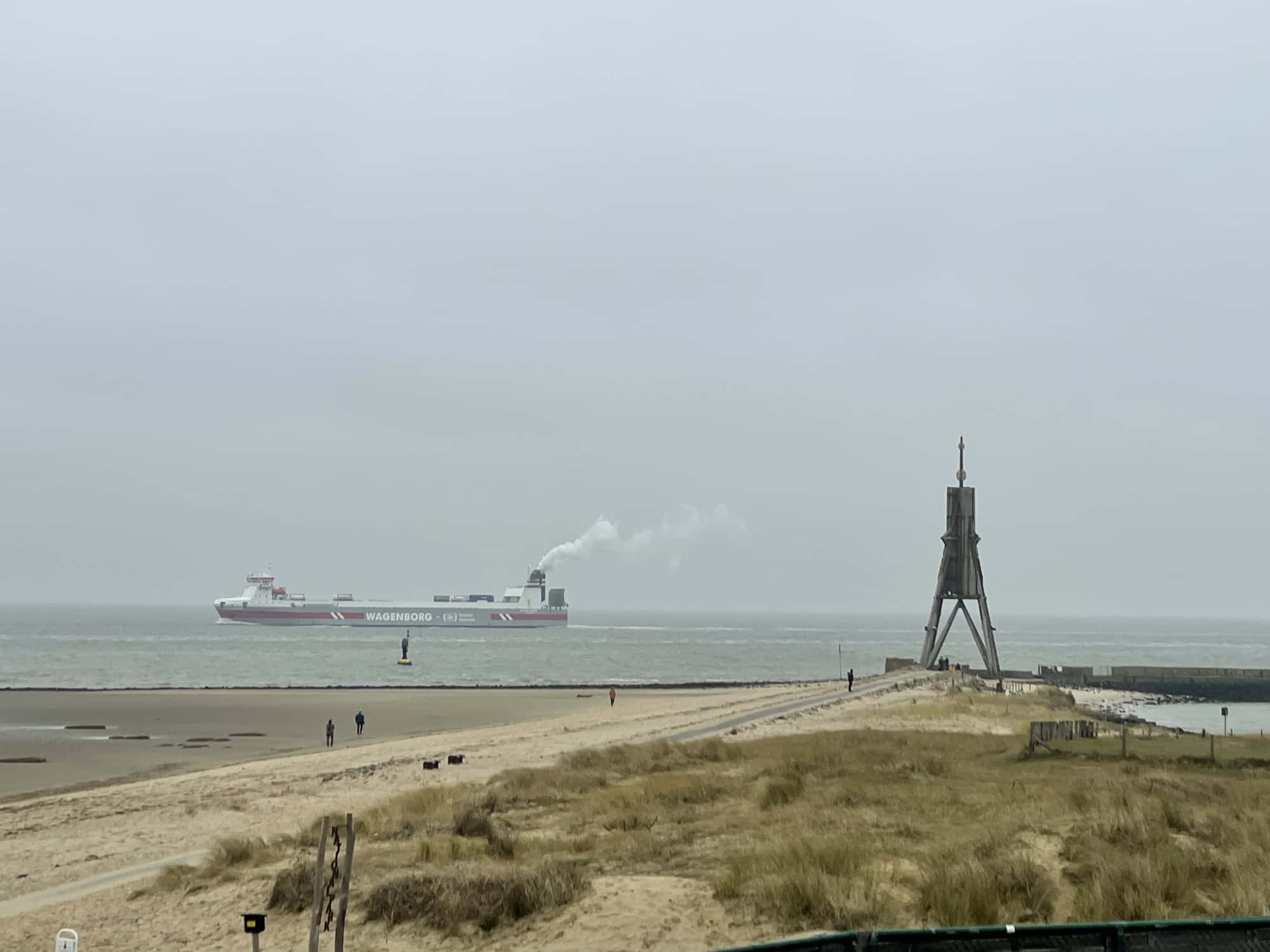 Wasserfontäne auf dem dunklen Teich mit Rasen im Vordergrund abends.