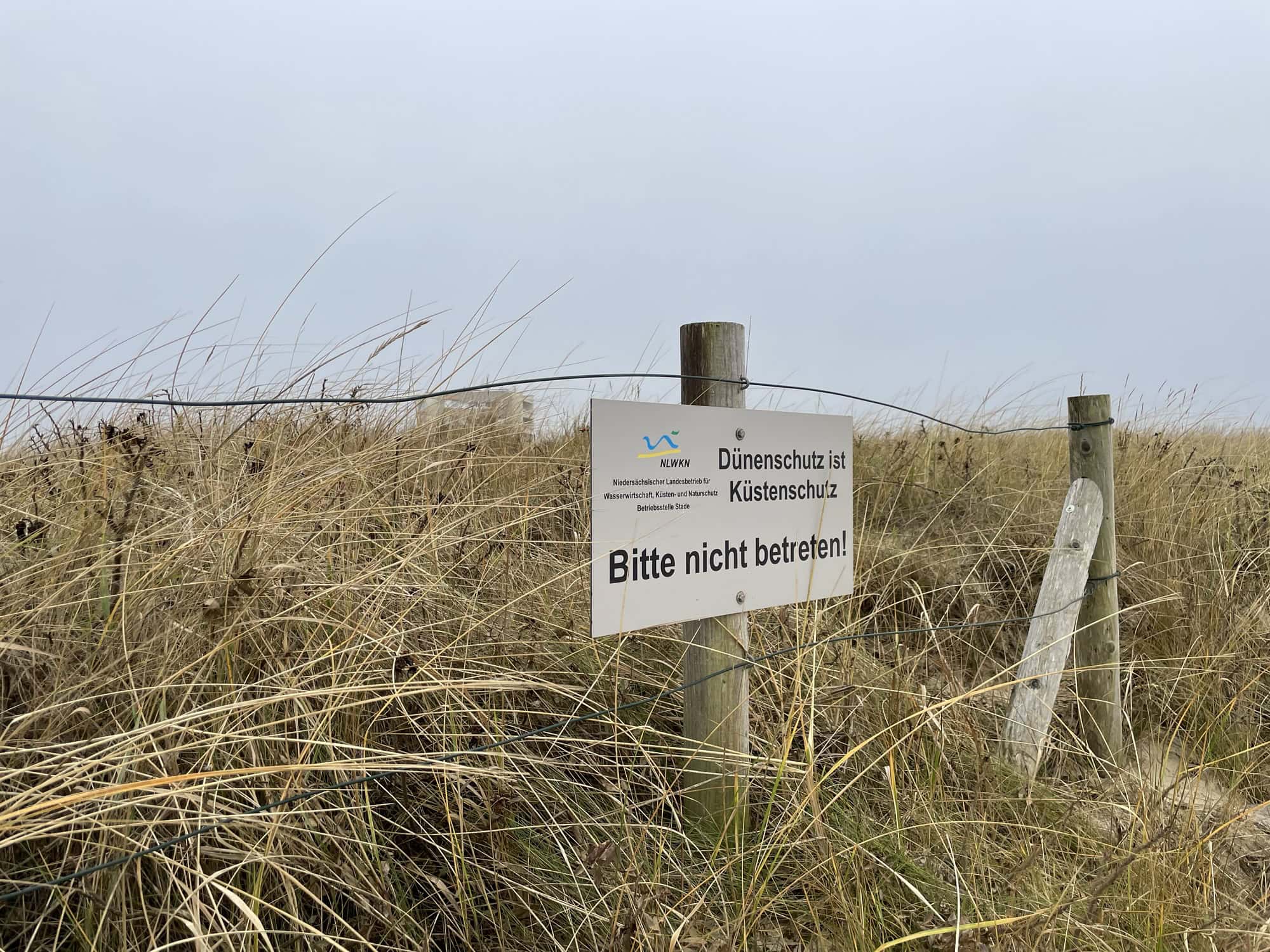 Eingezäunte Dünenbereich mit Betreten-verboten-Schild.