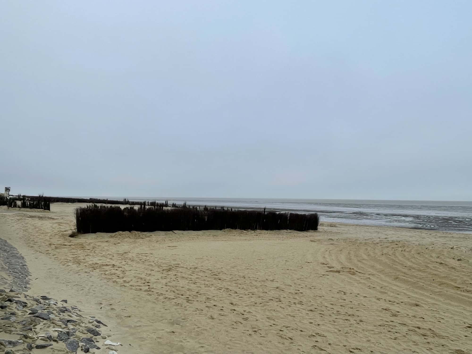 Strand mit Hecken gehen Sandabtrag.