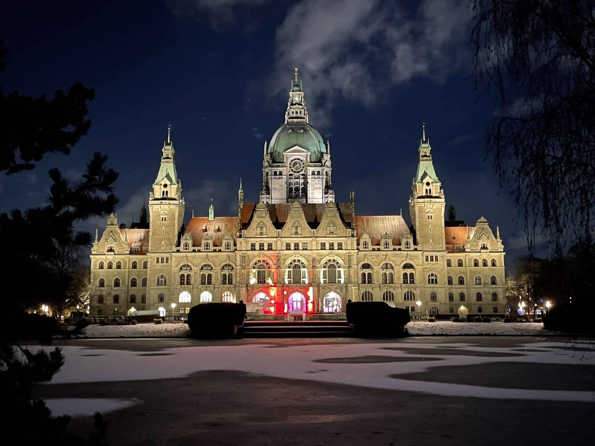 Das Neue Rathaus illuminiert im Dunkeln von der Maschparkseite.