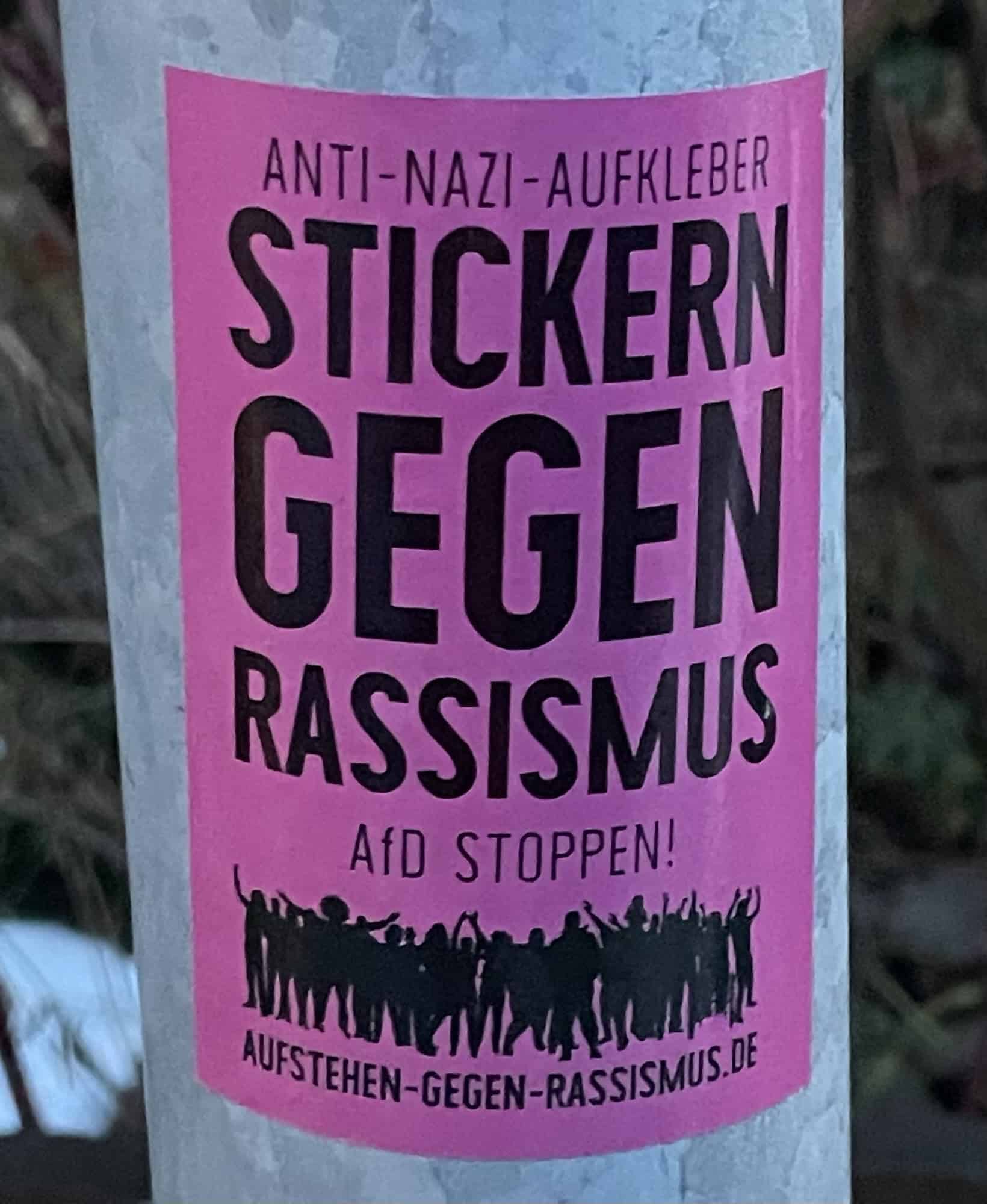 'ANTI-NAZI-AUFKLEBER STICKERN GEGEN RASSISMUS AfD STOPPEN!' an Laternenpfahl.