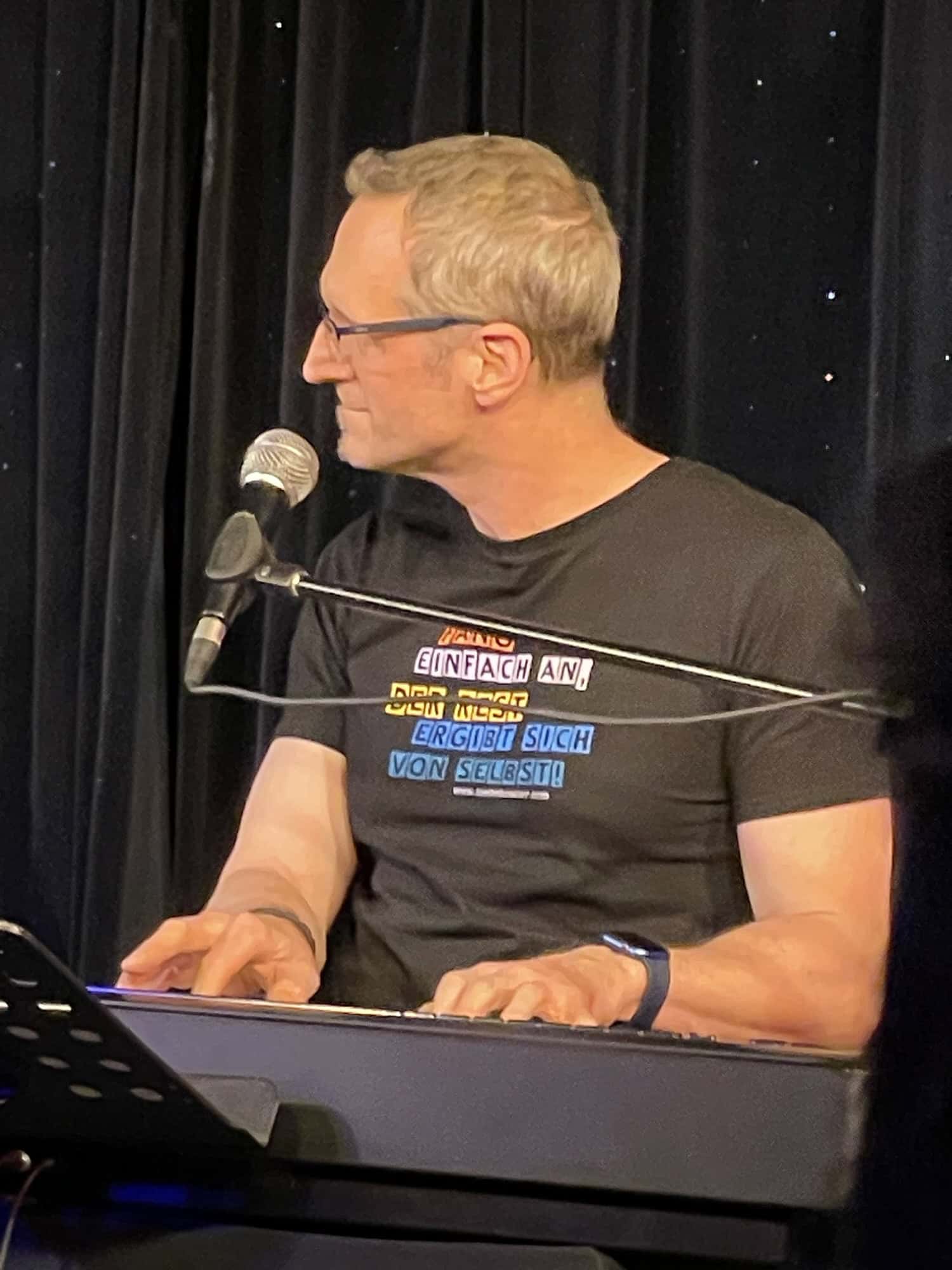 Der Keyboarder, Helge Adam (Piano & E-Bass), mitsingend.