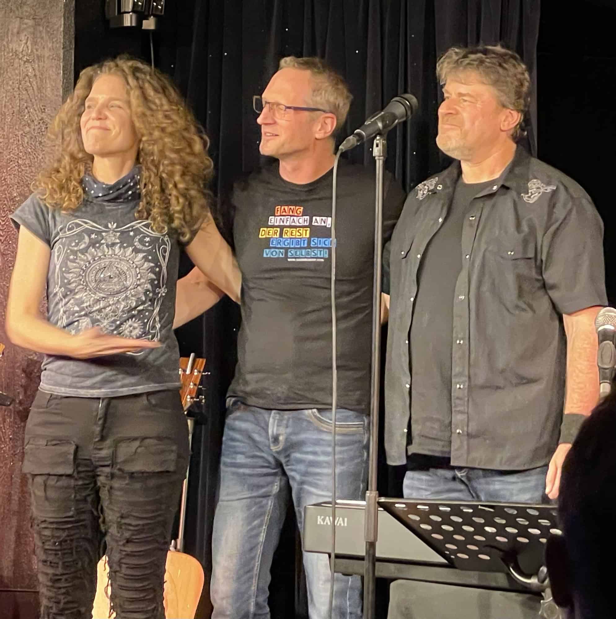 Die drei Musiker beim Schlußapplaus stehend.