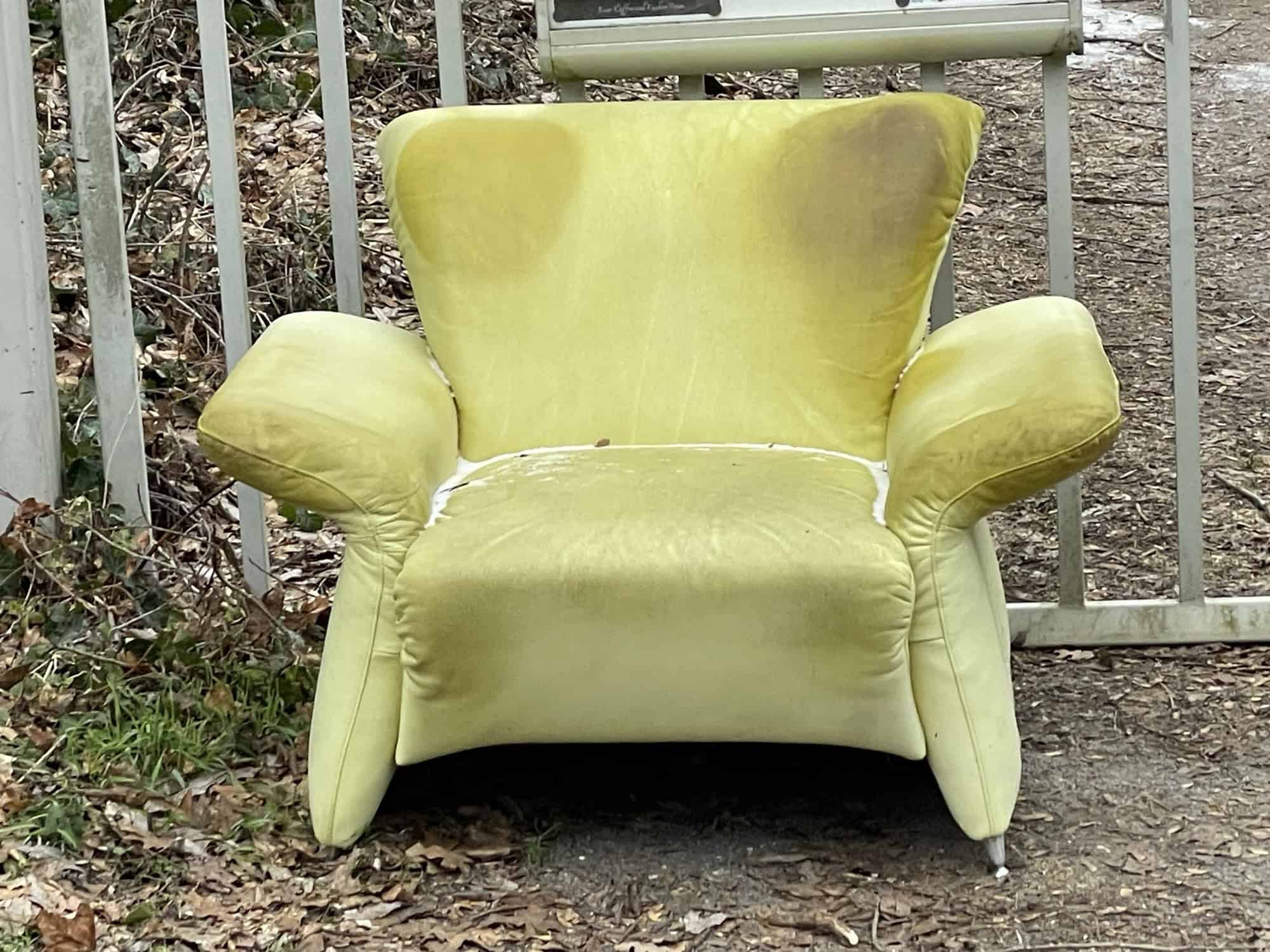 Hellgrüner Sesel draußen vor Gartensnlsgeneingang in Frontalsicht.