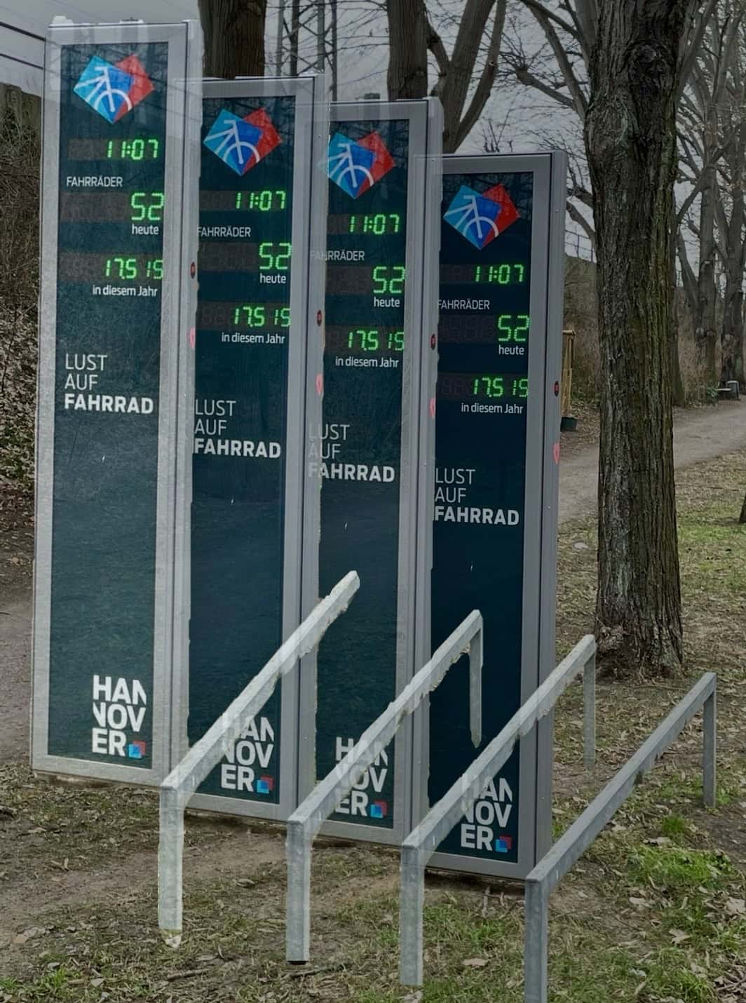 Fahrradmesdpunkt am Wegesrand vervierfacht als Fitomobtage, im Hintergrund Bäume und der Bahndamm.