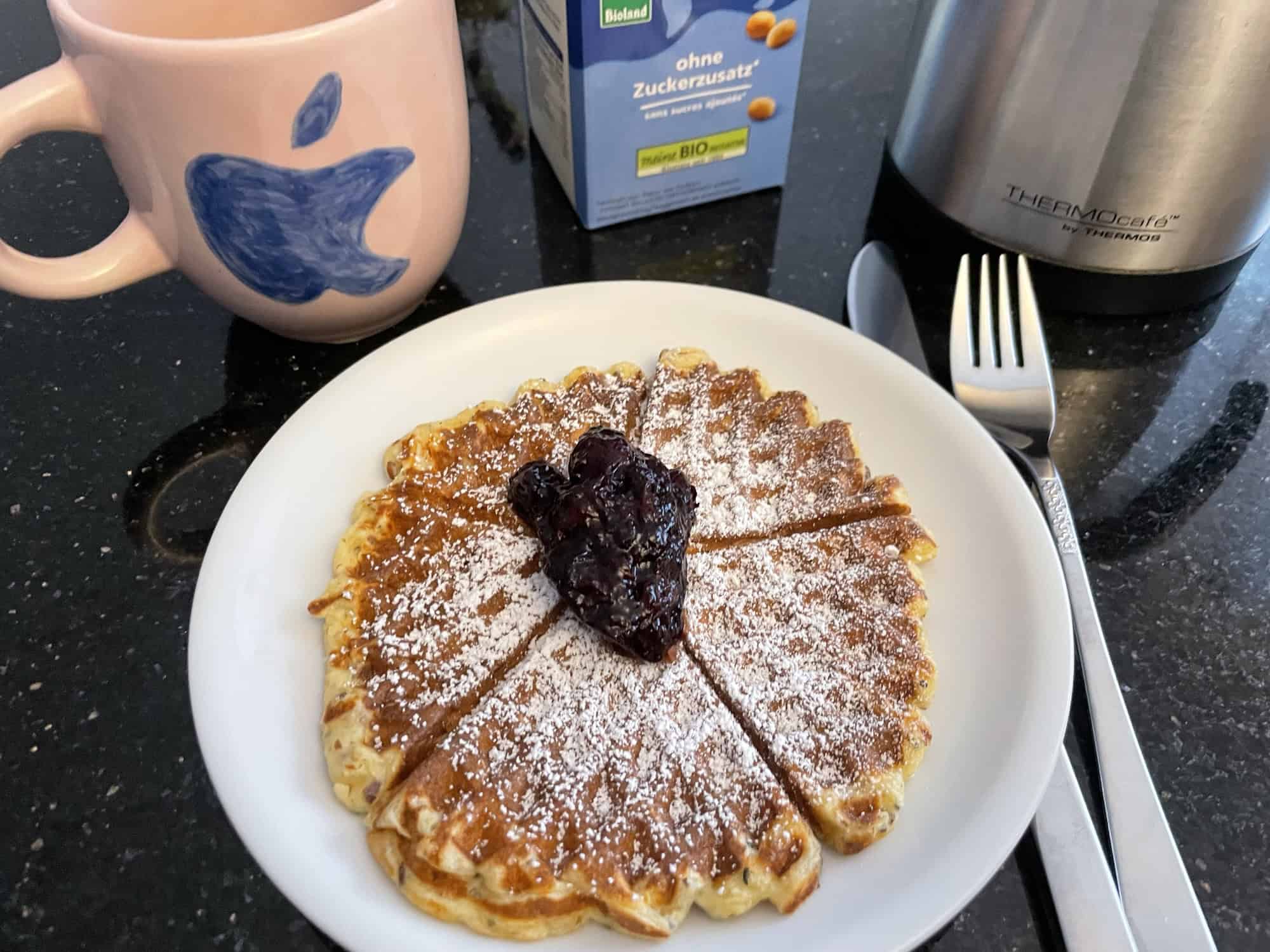 Schwarzer Stargalaxygranticouchtisch mit Teller Waffel mit Klecks Heidelbeerkompot, Kaffeetasse, Sojamilch-tetrapack und Kaffeekanne.