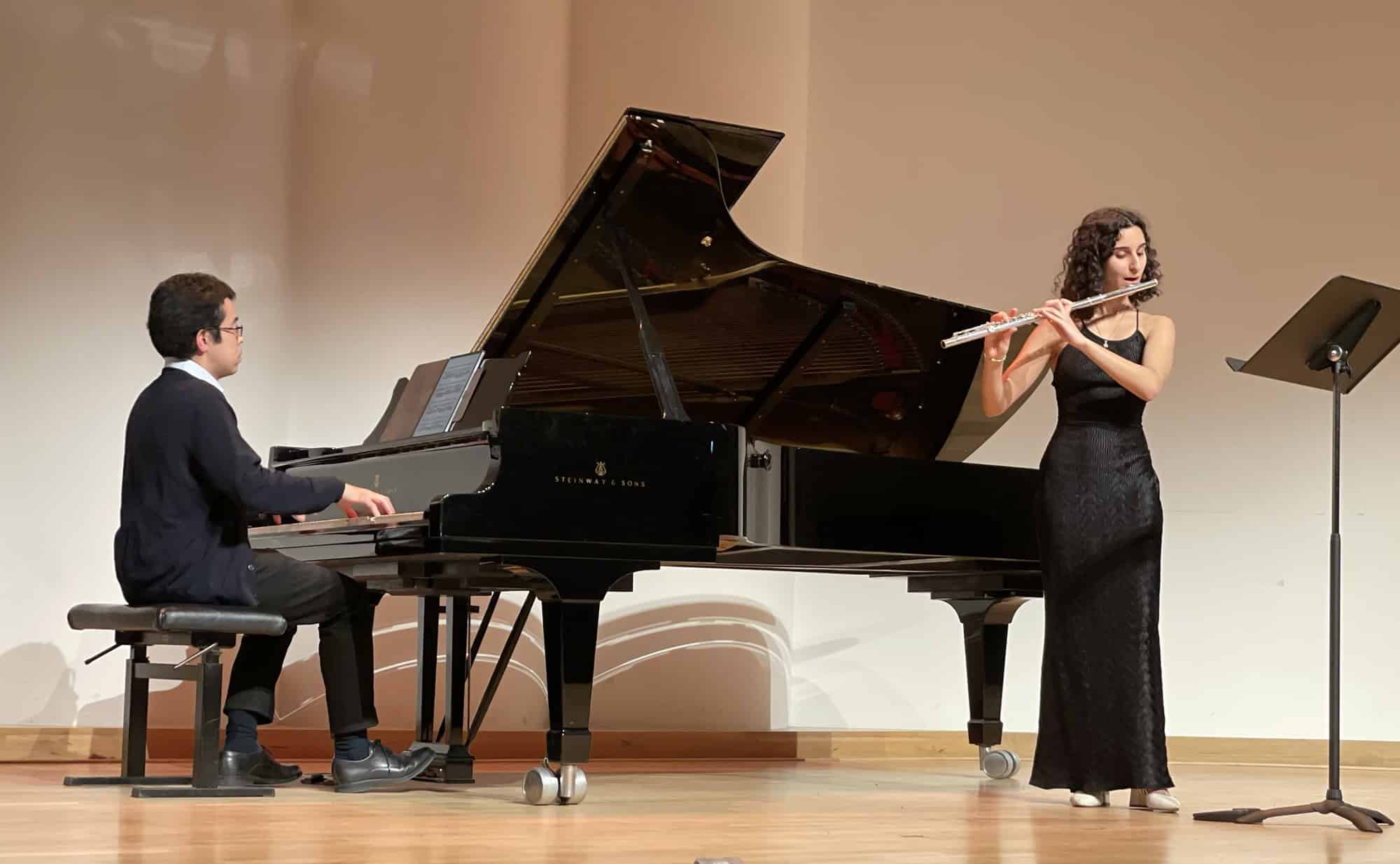 Pianist am Flügel und Flötenspielerin auf der Bühne beim Musizieren.
