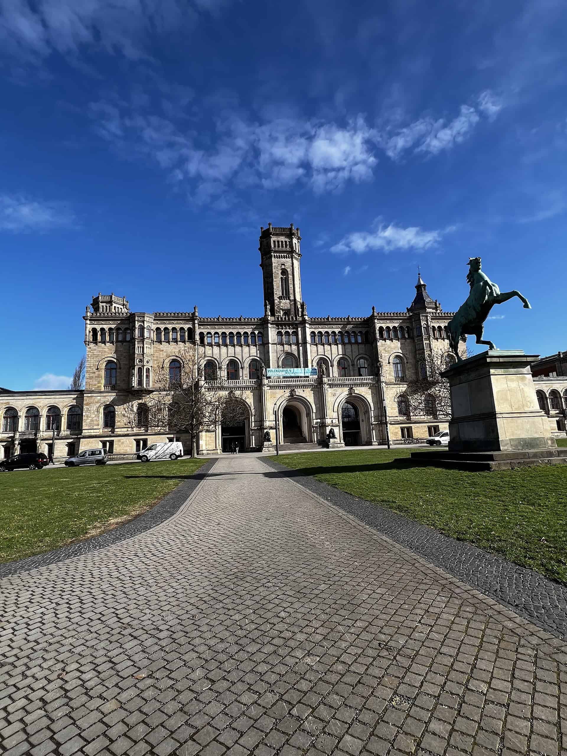 Gepflastert Weg zur Leibniz Universität Hannover mit Welfenschloß im Hintergrund.