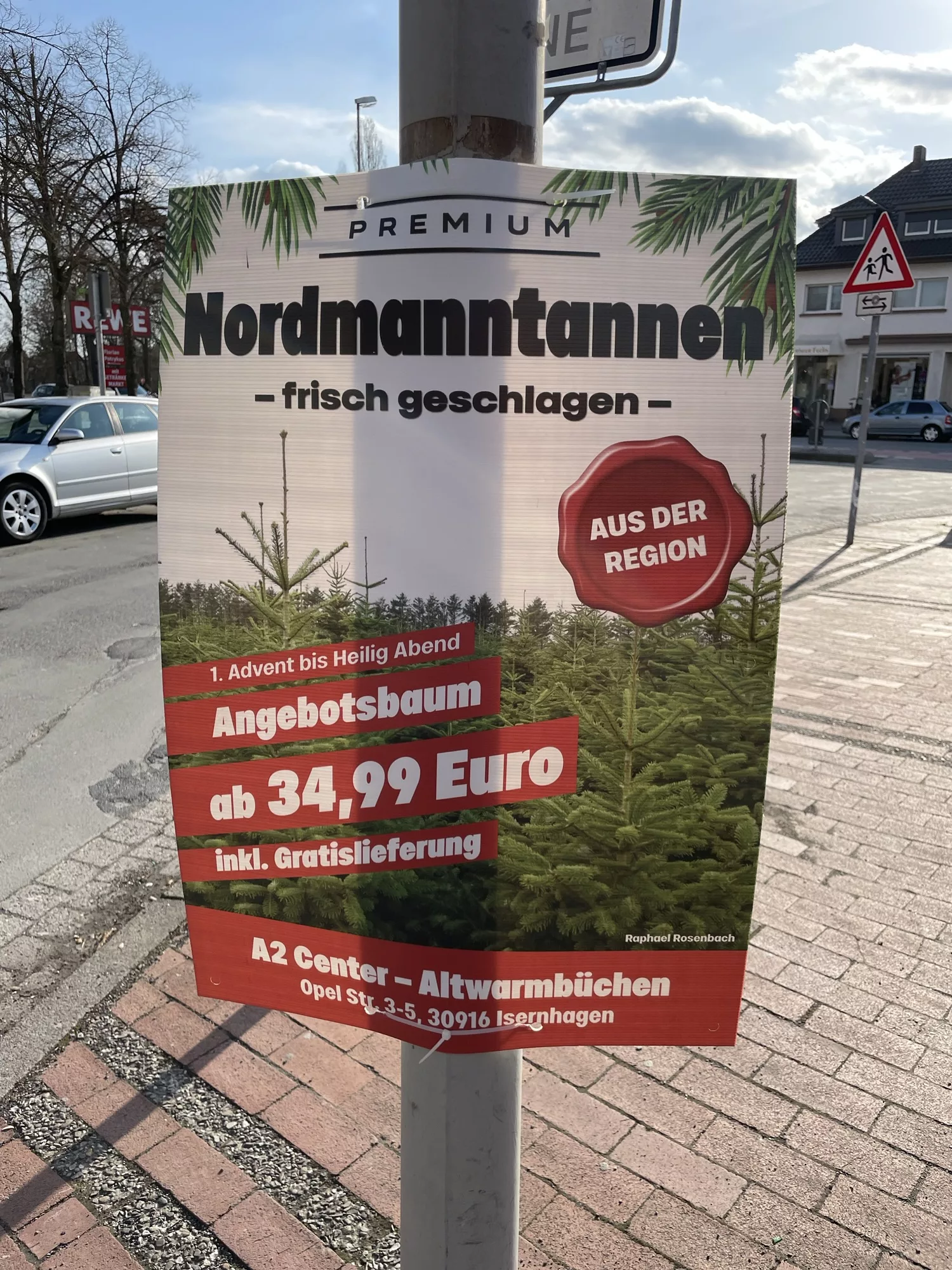 Plakat an Laternenmast mit Nordmannstannem im Weihnachtsveekauf.
