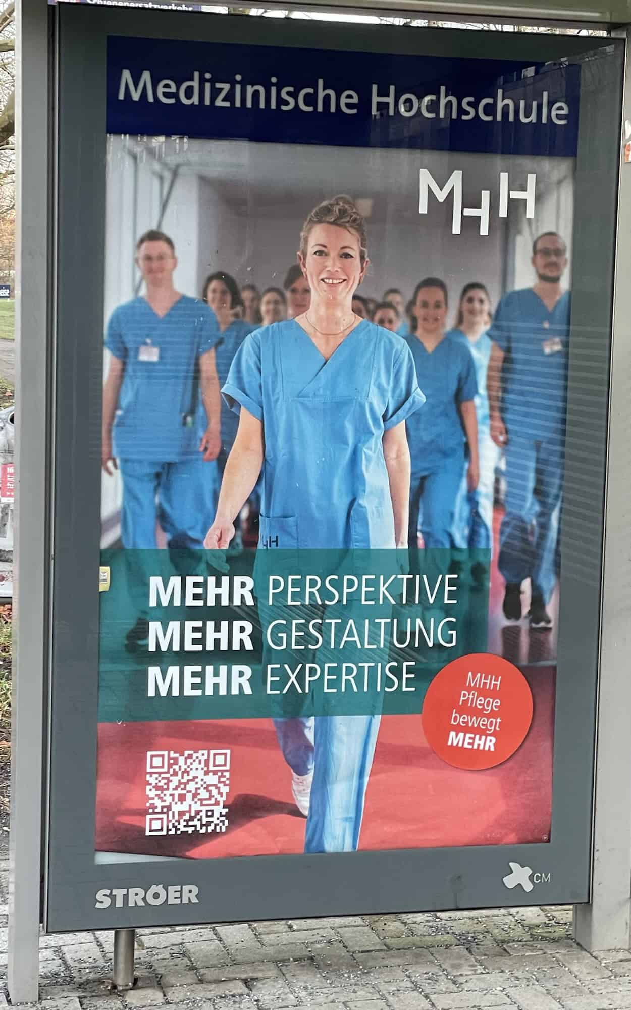 Üstra-Wartehäuschen mit MHH-Werbung: Pflegerin in blau vorne mittig, weitere dahinter mit Slogan: MEHR PERSPEKTIVE MEHR GESTALTUNG MEHR EXPERTISE