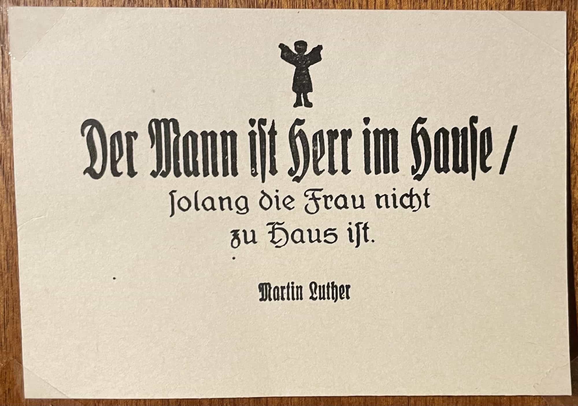 Postkarte mit: Der Mann ist Herr im Hause solange die Frau nicht zu Hause ist. Martin Luther
