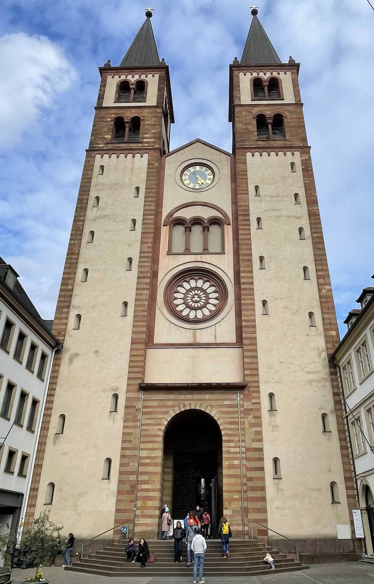 Großes sandfarbenes Kirchebportal mit zwei Türmen links und rechts.