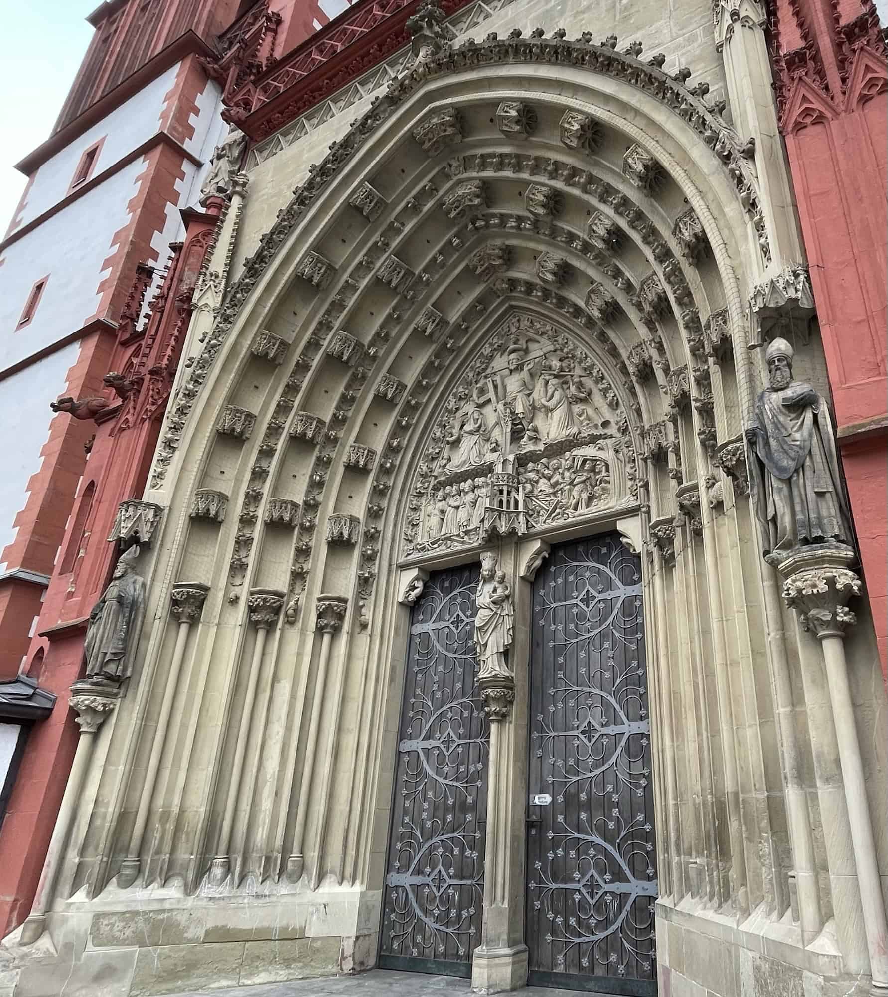 Eingangsportal Kirche mit Holztür und Ausschmückungen um die Tür.