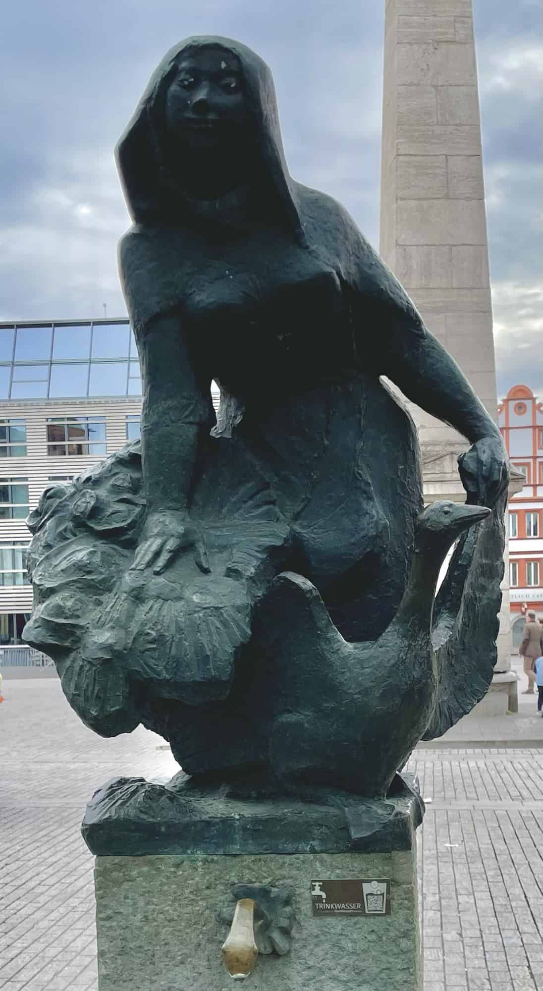 Steinerne Frauenskulpur auf Brunnen.