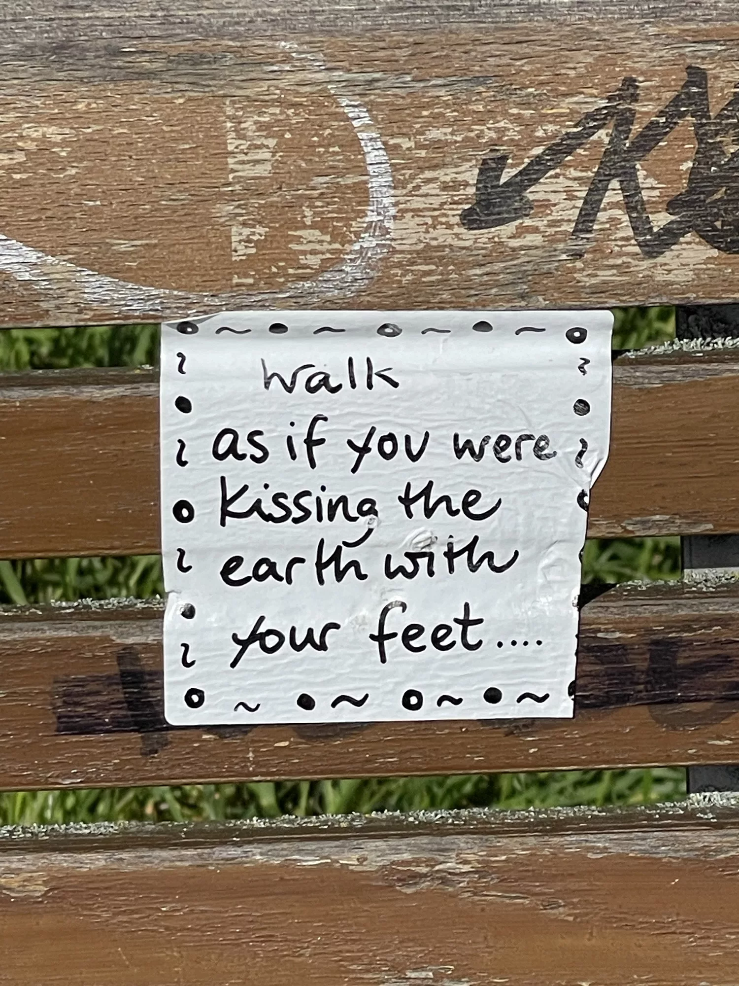 Aufkleber auf Bank: Walk if as if you were Kissing the earth with your feet....