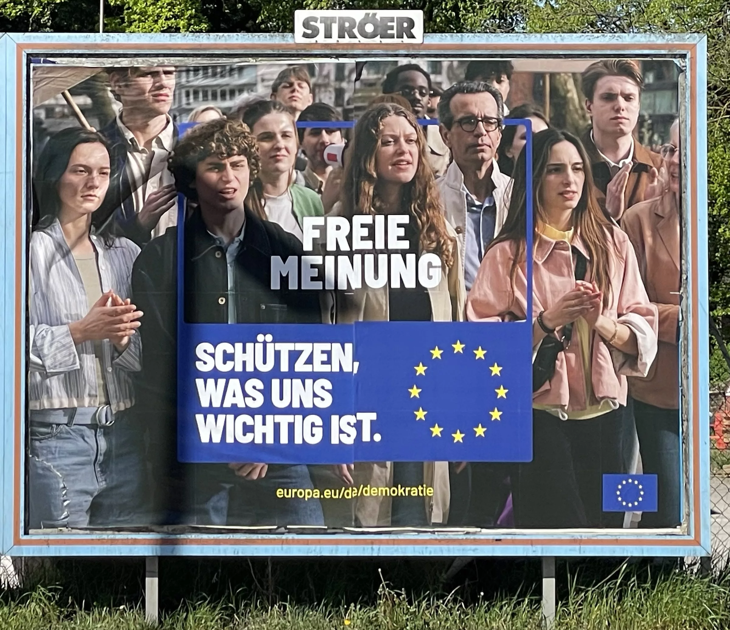 Großplakat Personen, stehend dazu Slogan 'FREIE MEINUNG SCHÜTZEN, WAS UNS WICHTIG IST.' mit EU-Sternen.