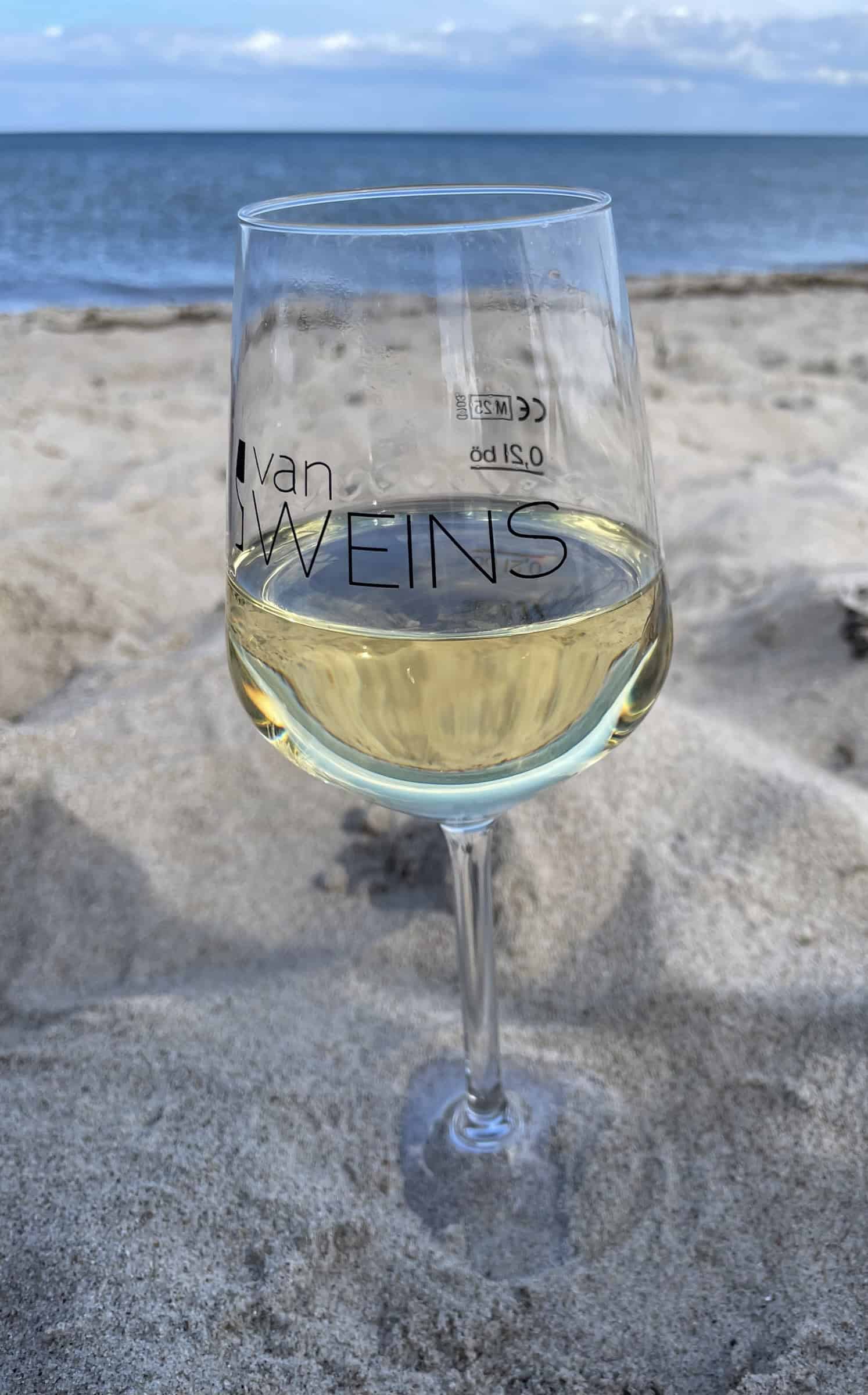 Glas Weißwein am Strand.