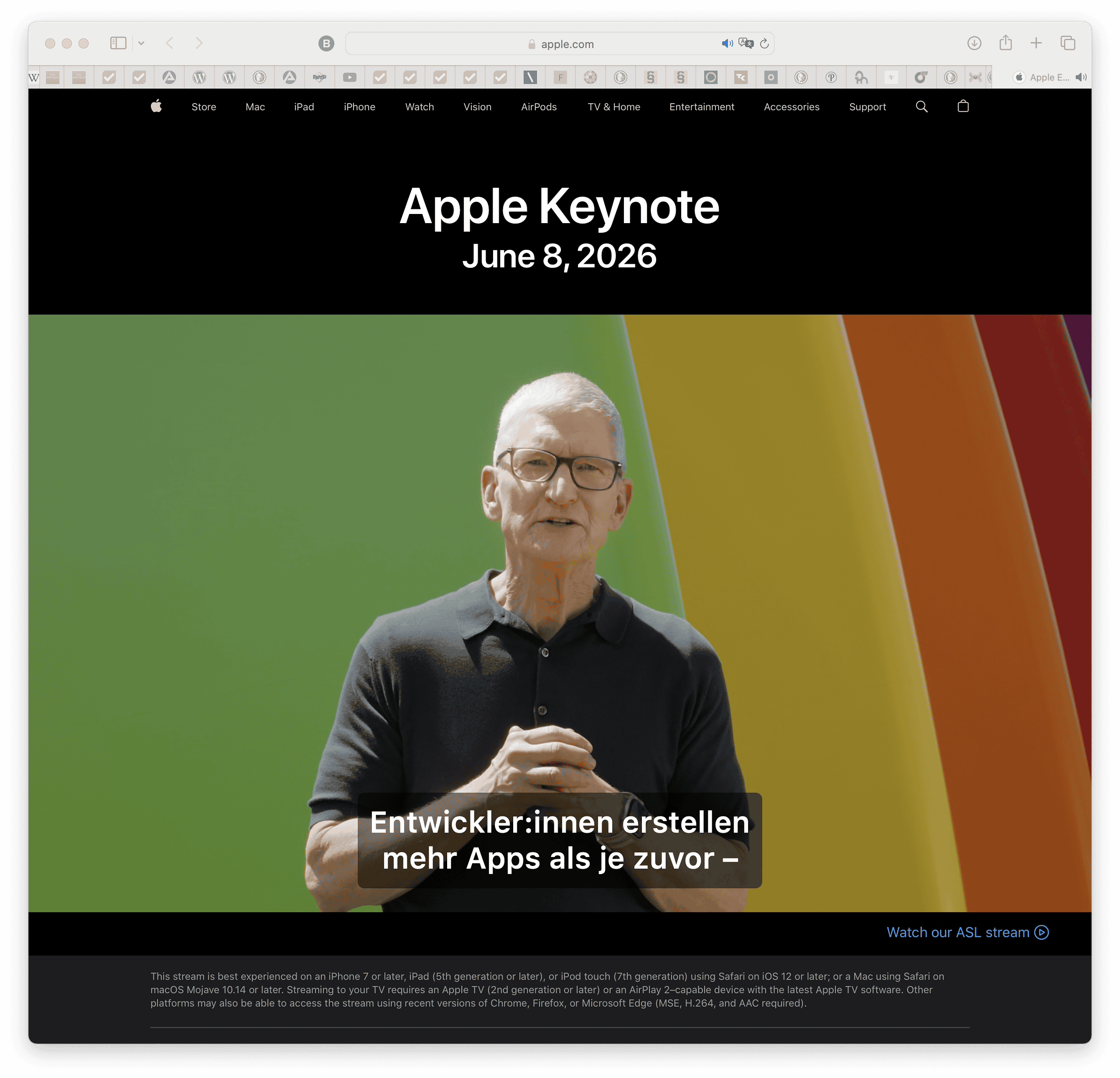 Tim Cook steht im Apple Park vor den Regenbogenelementen.