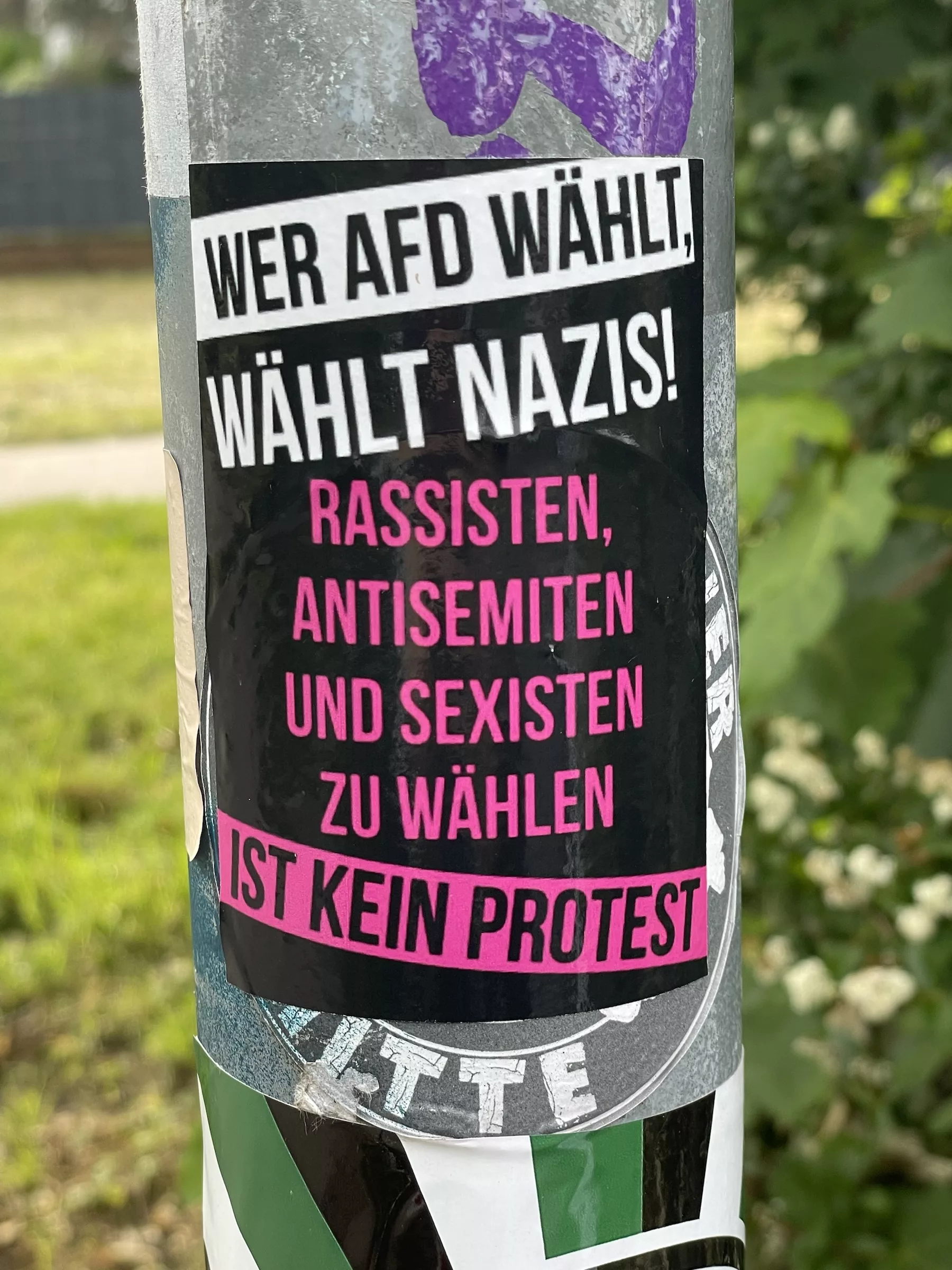 Aufkleber an Schild: WER AFD WÄHLT! WÄHLT NAZIS! RASSISTEN, ANTISEMITEN UND SEXISTEN ZU WÄHLEN
IST KEIN PROTEST