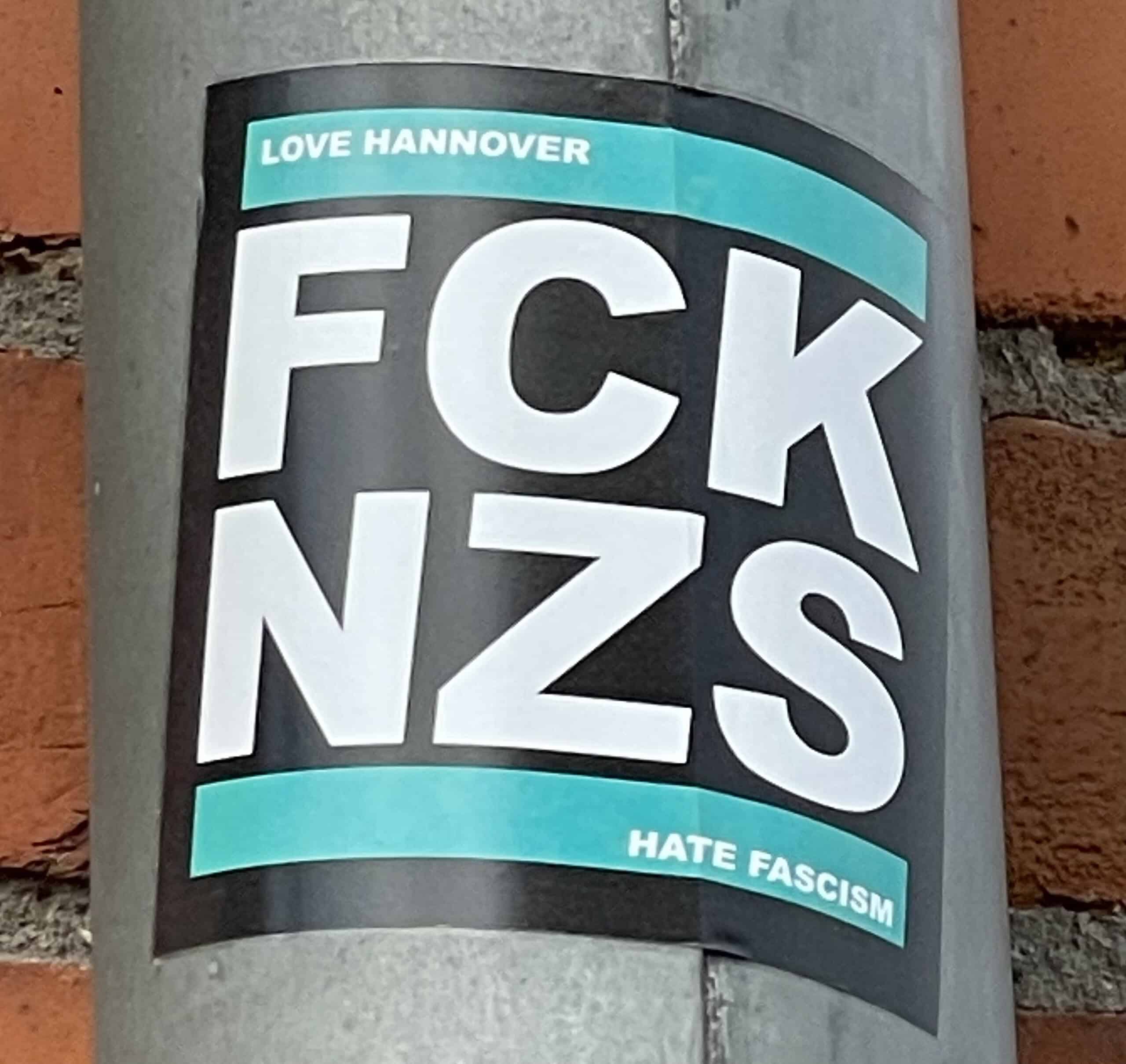 Aufkleber an Laternenpfahl: LOVE HANNOVER FCK NZS HATE FASCISM