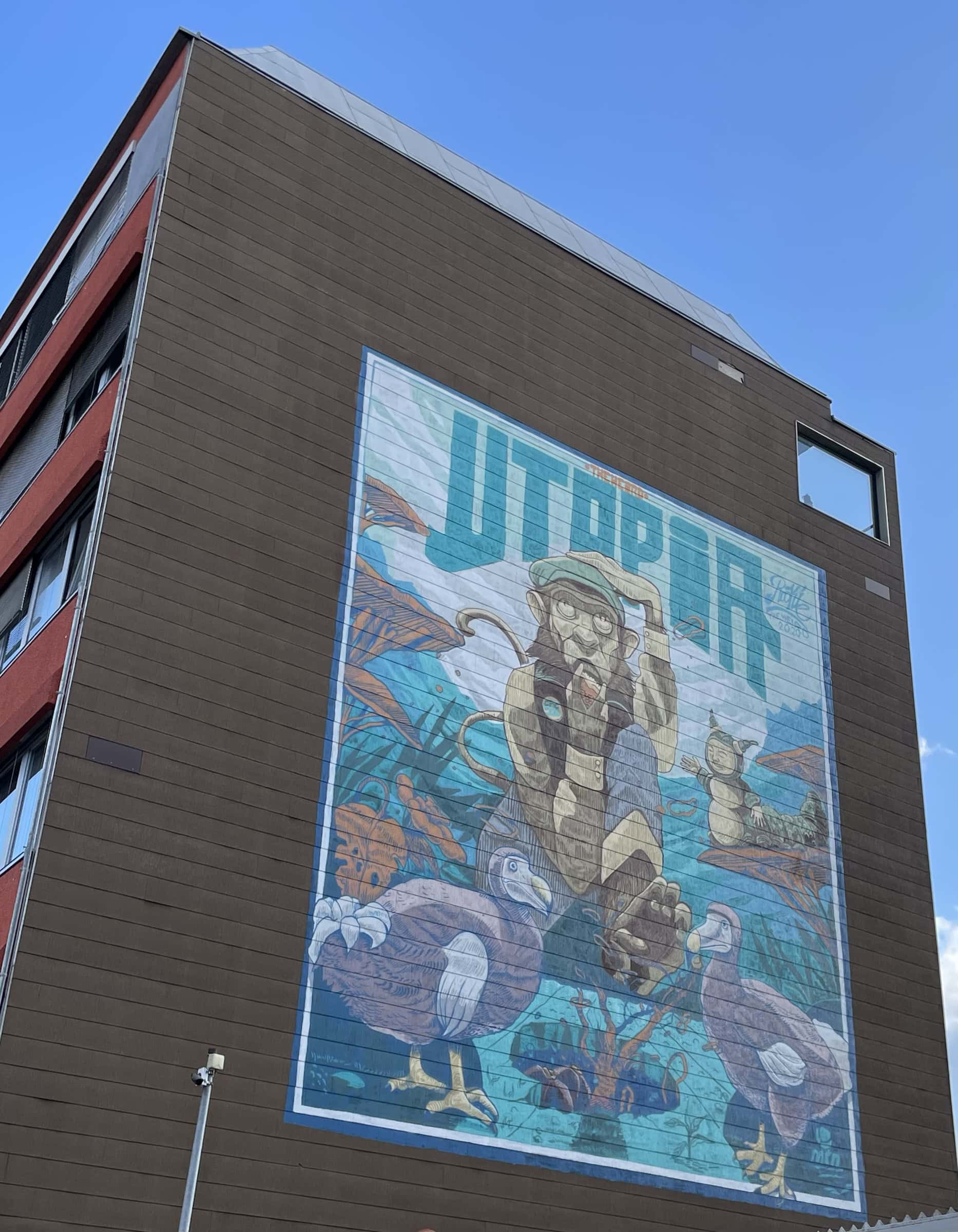 roßwandbild an Hauswand namens Utopia mit Zerg, 2 Hasen vor ihm und einer zauberartigen Schneckenperson.