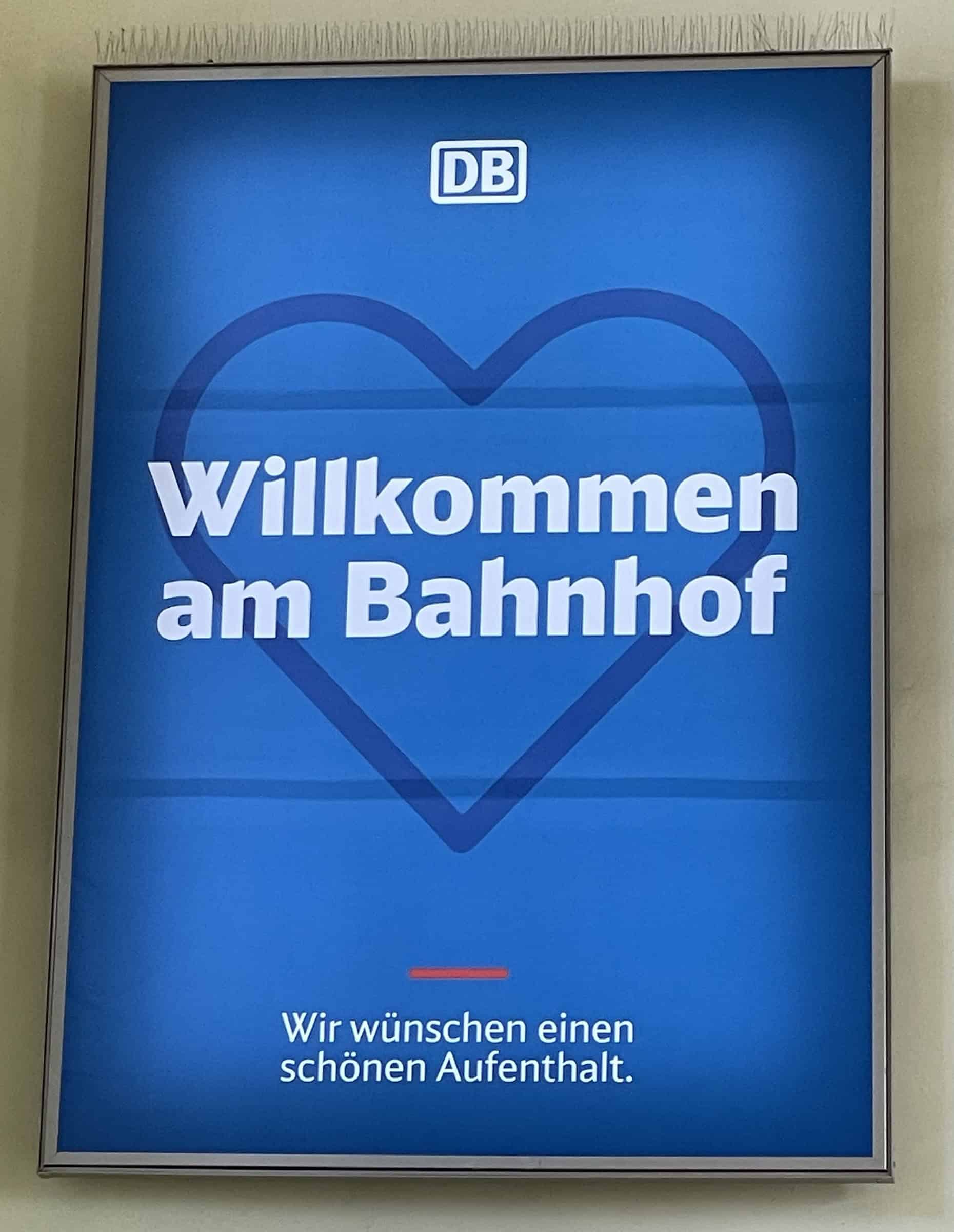 DB-Infoscreen-Rwklame ab Bahnhofswand: Willkommen am Bahnhof. Wir wünschen einen schönen Aufenthalt.