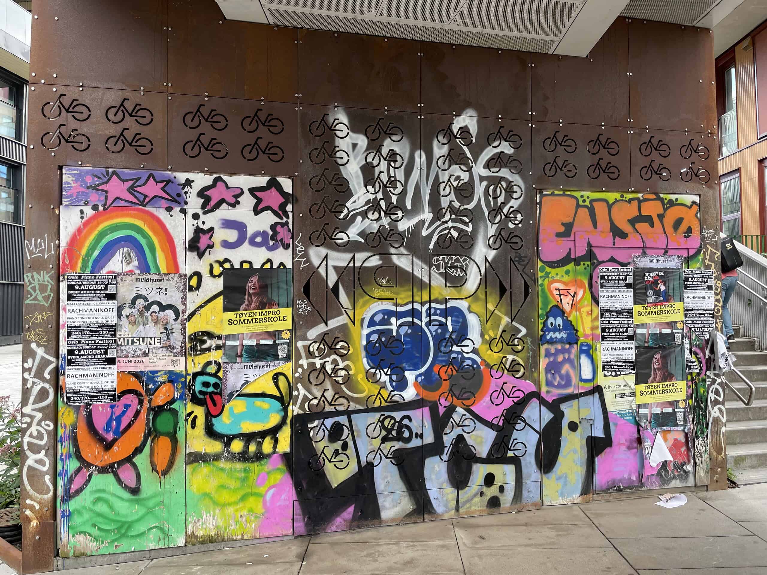 Brückenwand voll mit Plakaten und Graffitis an der Station Ensjø in Oslo.