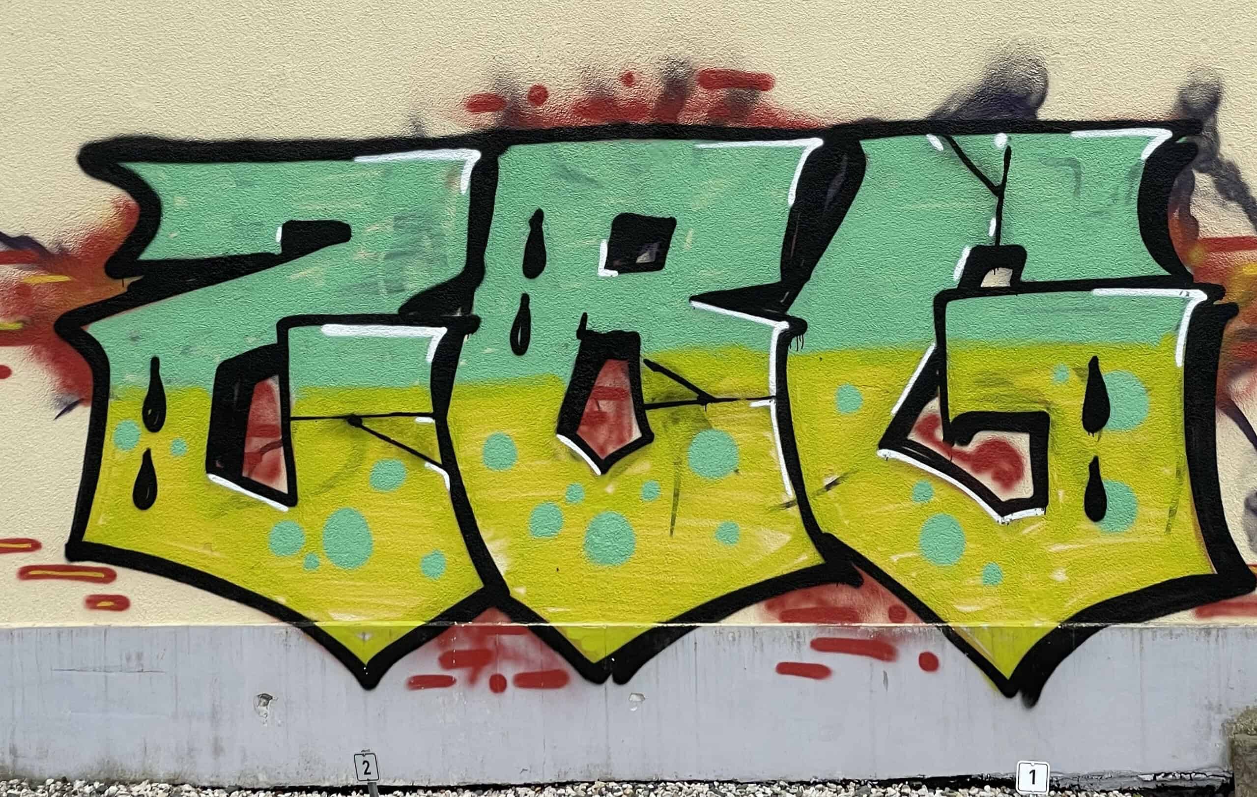 Grün-gelbes-Buchstabenragging als Graffiti an der Wand.