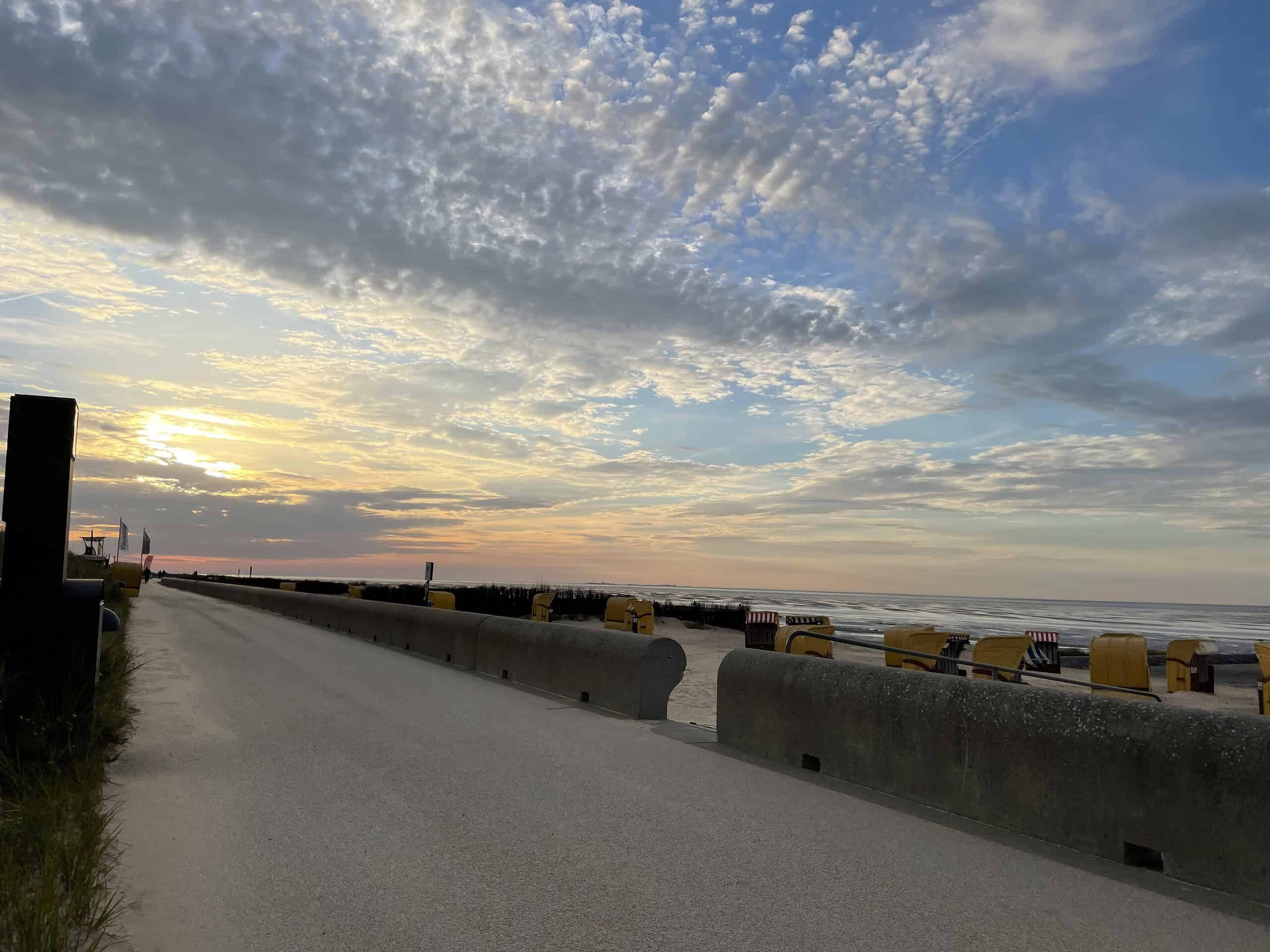 Fie Dtrandpromenade entlangs abends mit farbigen Himmel in Gelb, Orange, rot und blau.
