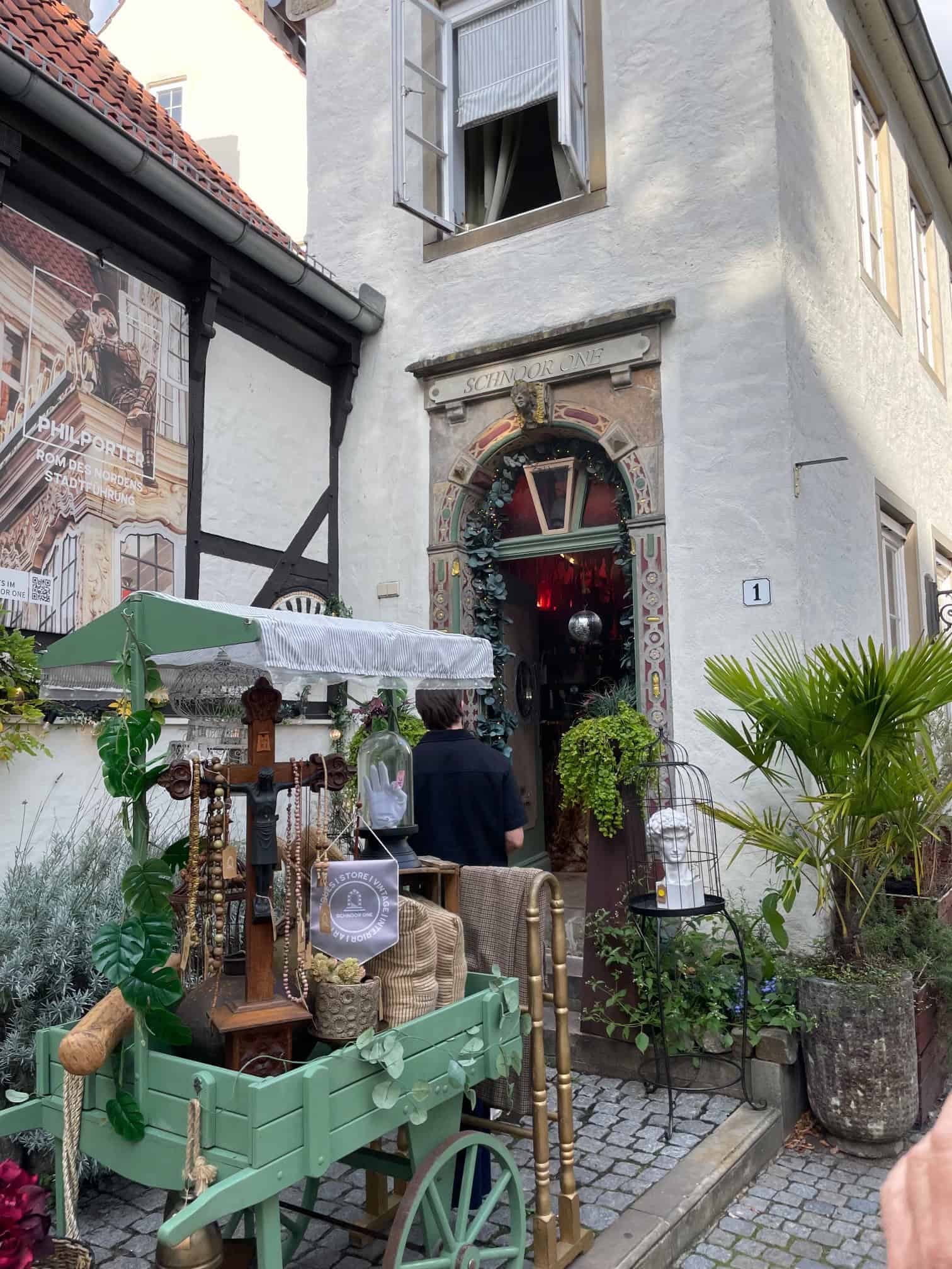 Hauseingang im Schnoorviertel mit Holzwägelchen und Dingen darauf davor.