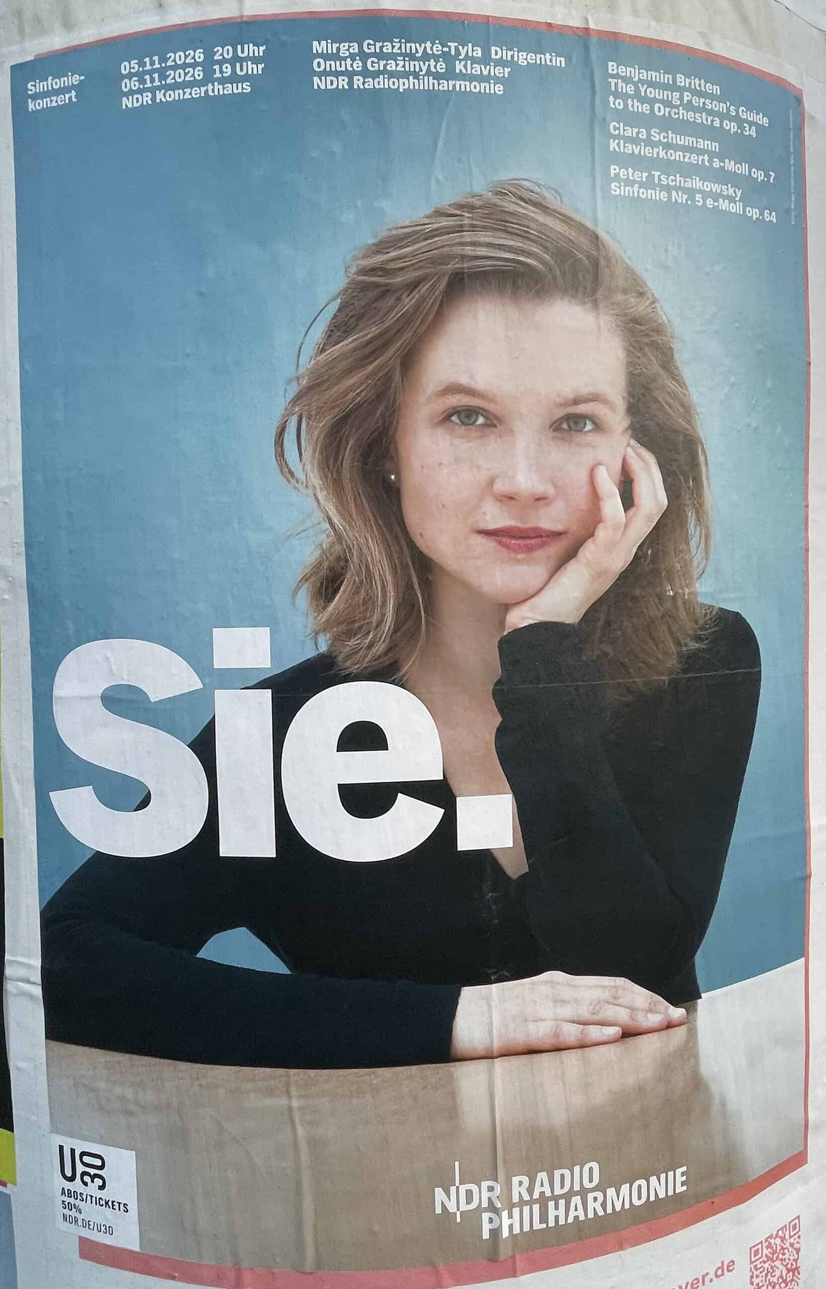 Konzerplakat für Sinfoniekonzert des NDR mit junger Frau (Oberkörper) und Schriftzug ‚Sie.‘.“
