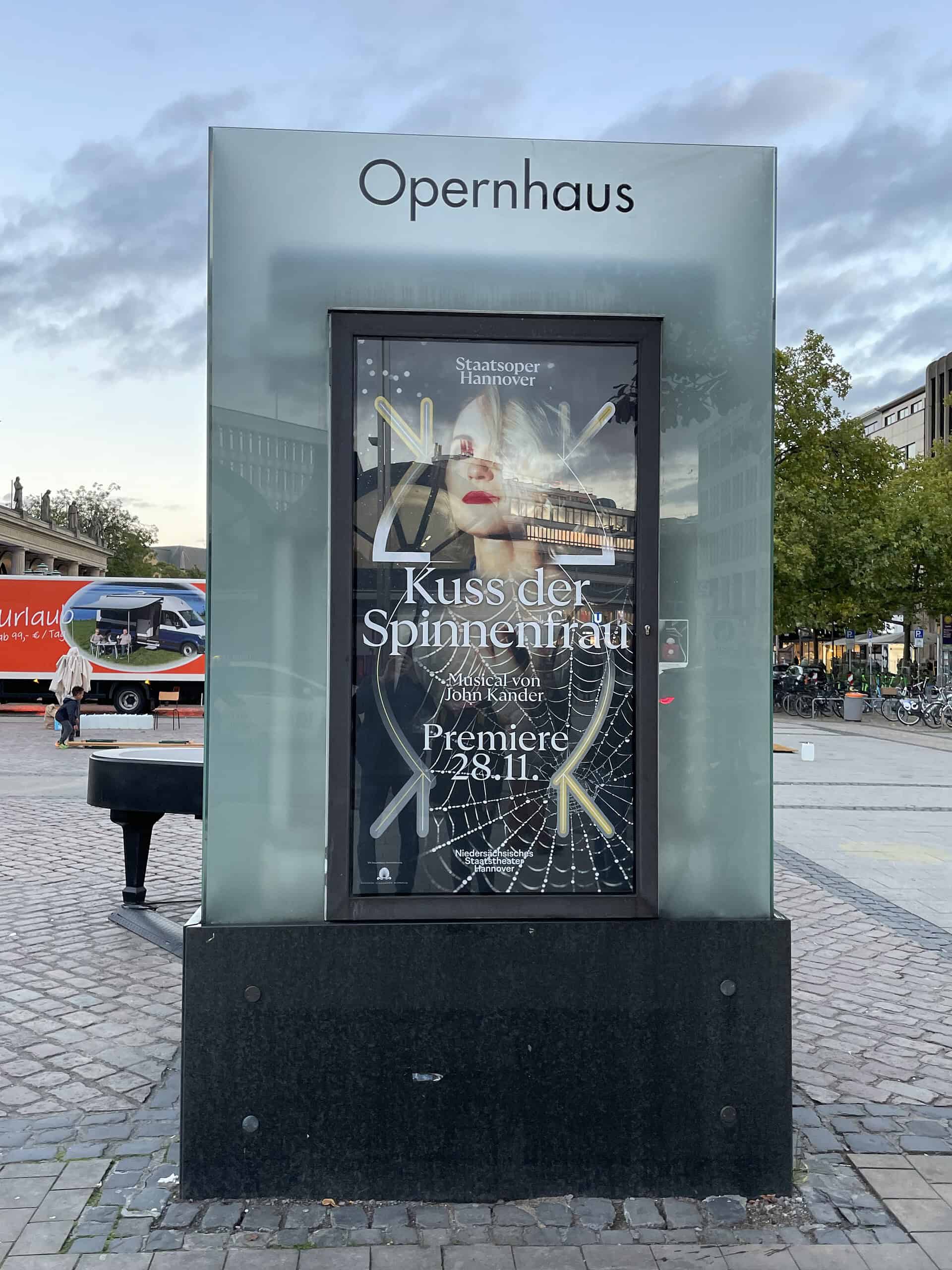Opernschaufenster mit Plakat: Kuss der Spinnenfrau